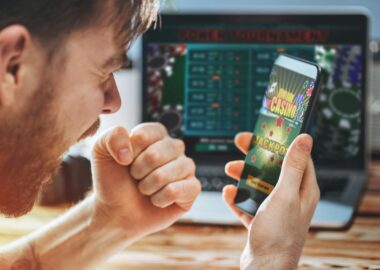 Un homme regarde un écran de téléphone avec une application de casino en ligne.