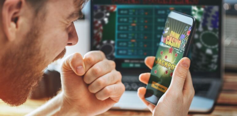 Un homme regarde un écran de téléphone avec une application de casino en ligne.