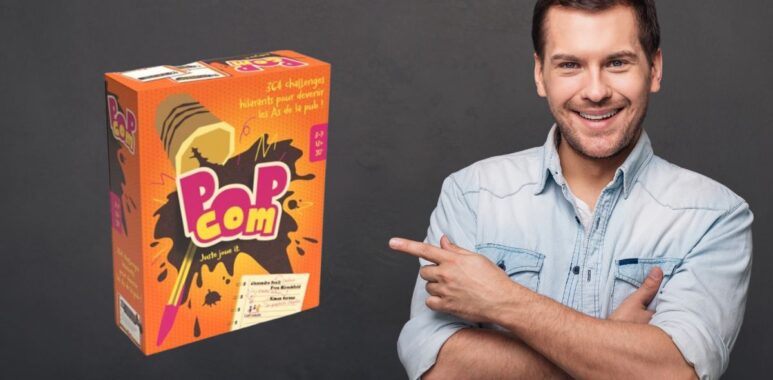 Un homme souriant pointant vers une boîte de jeu de société Pop Corn