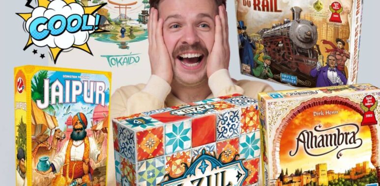 Un homme souriant entouré de boîtes de jeux de société comme Jaipur, Azul et Les Aventuriers du Rail.