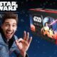 Un homme souriant devant la boîte du jeu Star Wars Unlimited